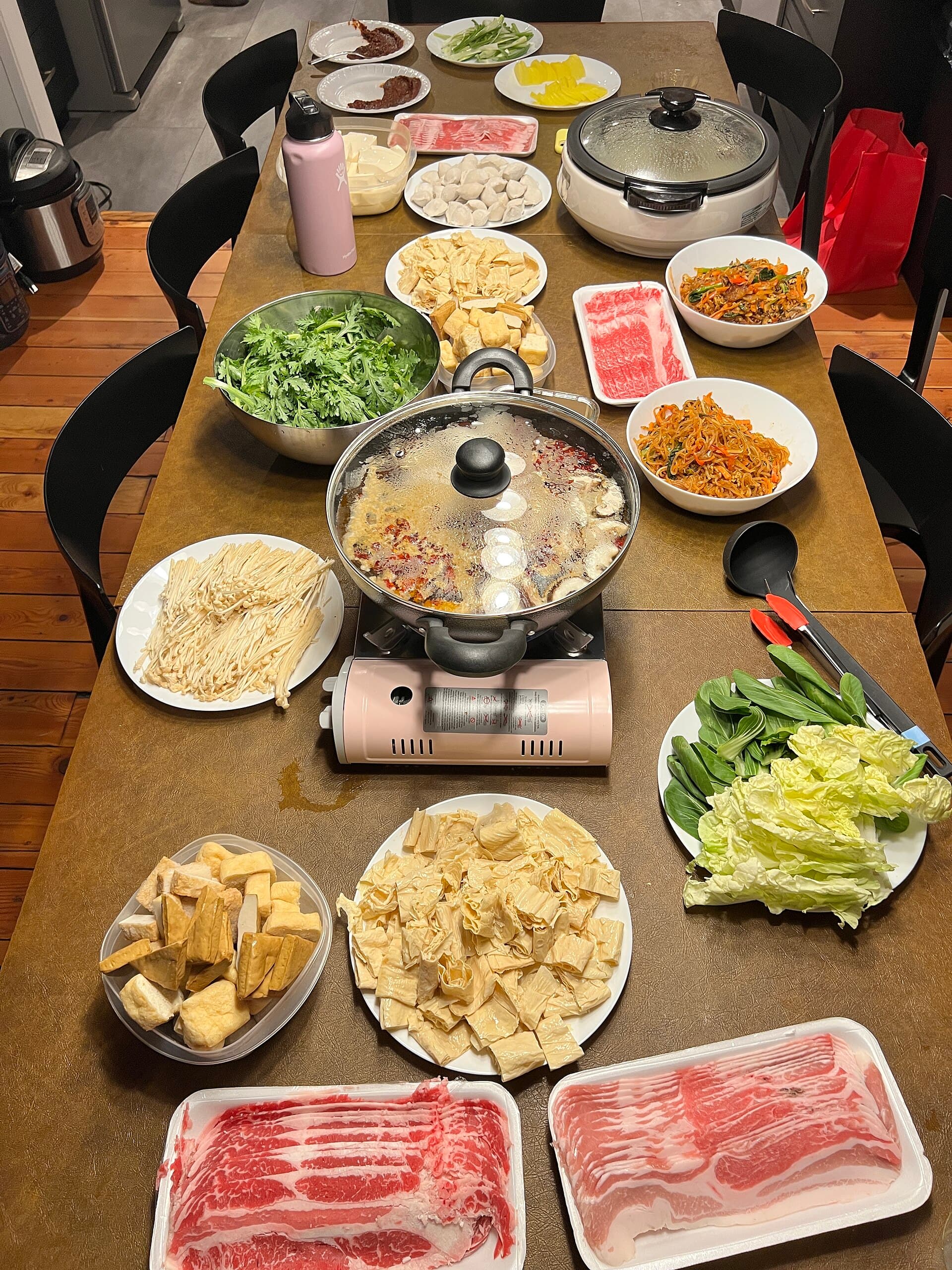 Hot pot chinois (huoguo) avec bouillon mijotant et ingrédients à tremper.