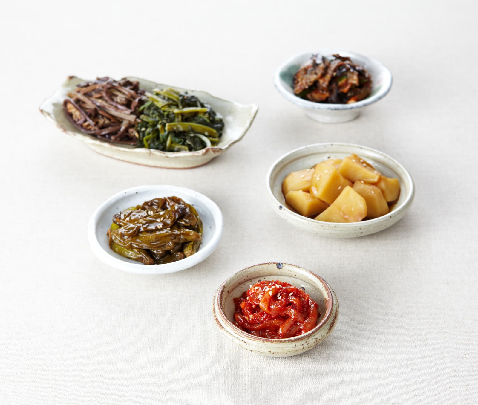 Assortiment de banchan, petits plats d'accompagnement coréens servis dans de multiples bols.