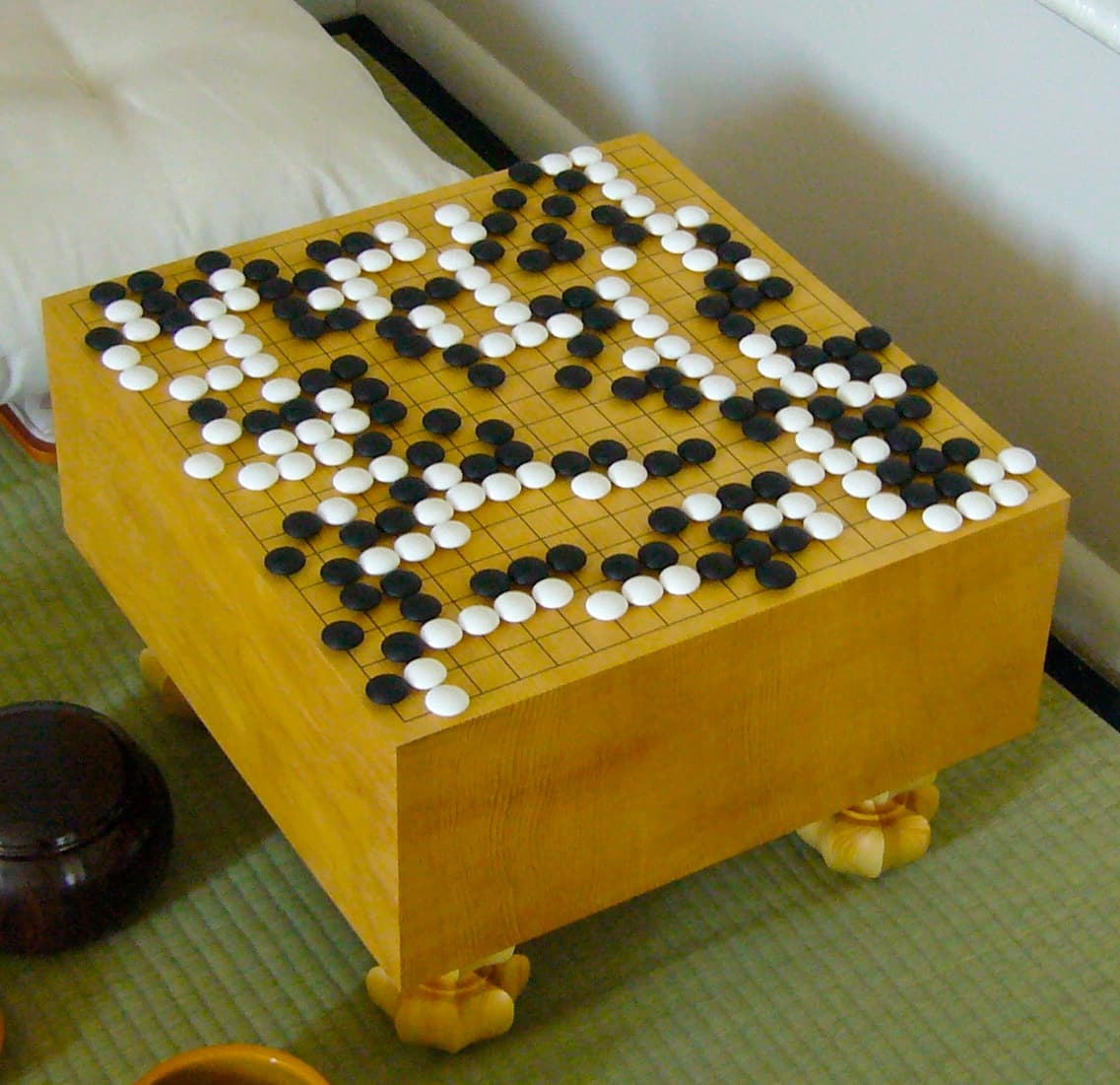 Goban (plateau de go/weiqi) avec pierres noires et blanches.