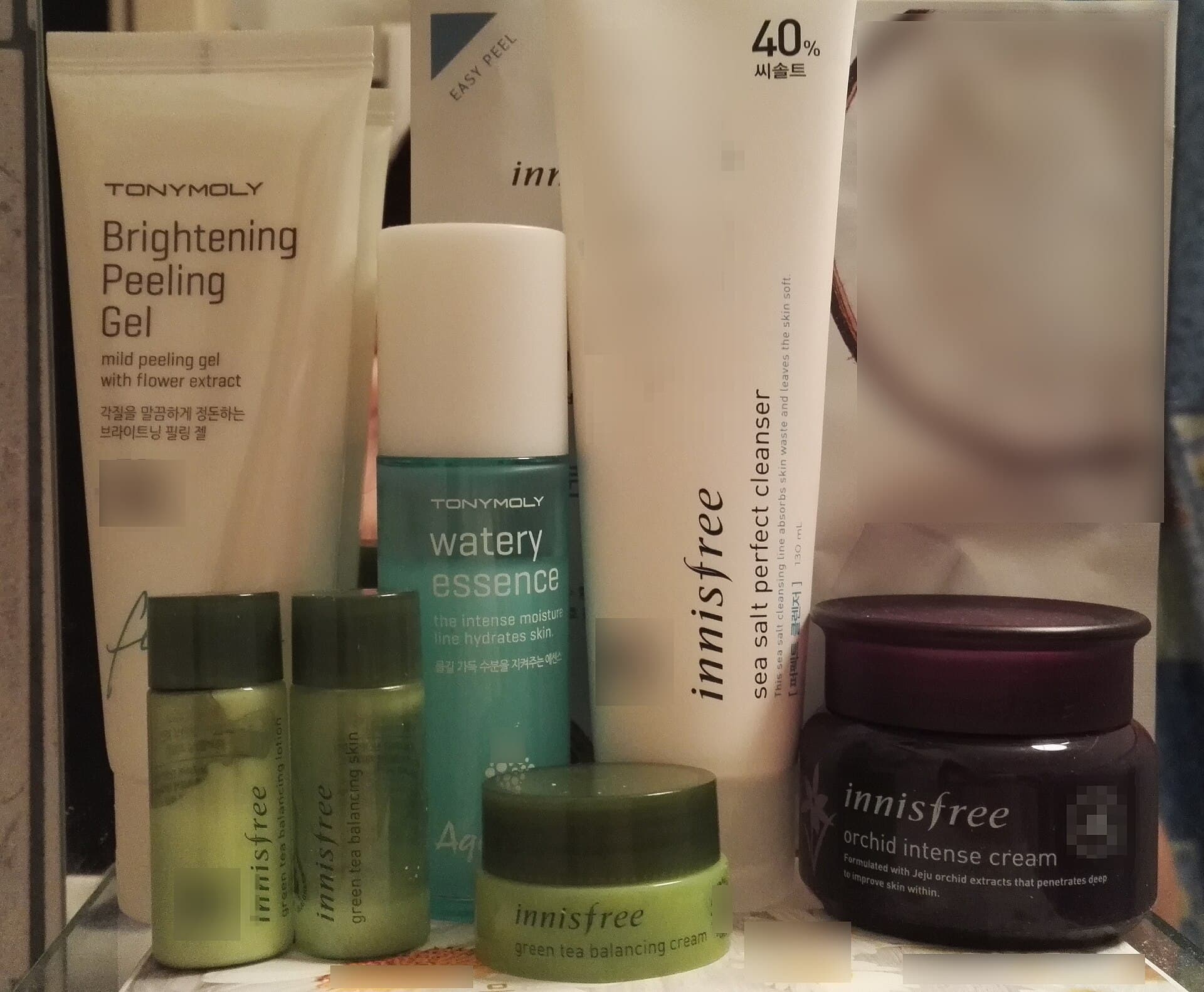 Assortiment de produits cosmétiques de soin coréens (flacons, tubes et pots) alignés sur une étagère.