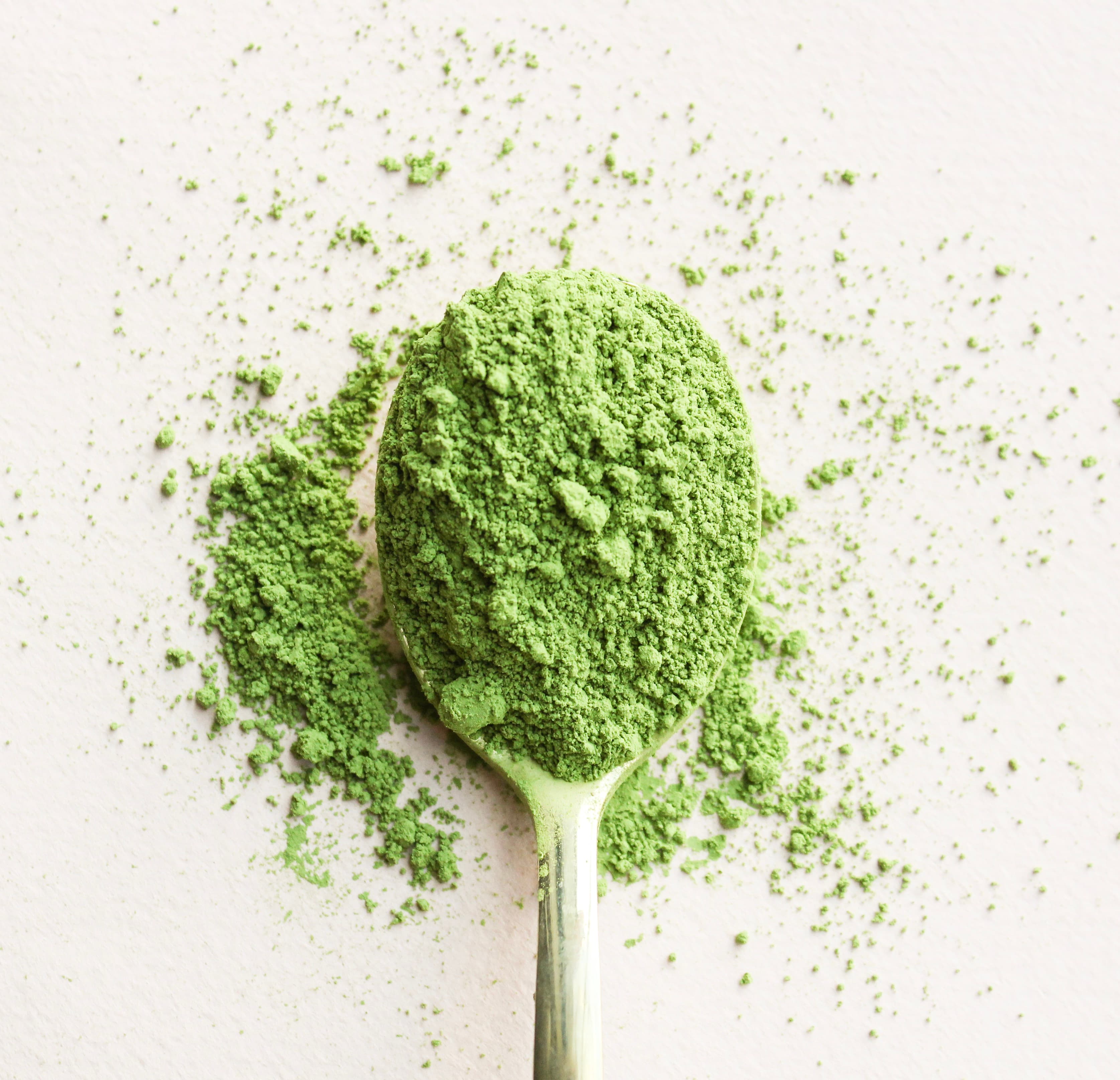 Poudre de thé vert matcha japonais avec une cuillère en bambou.