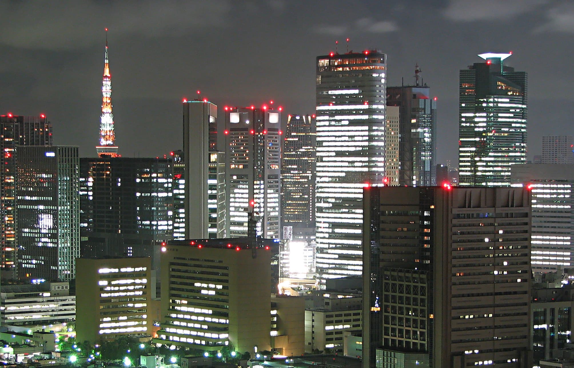 Vue nocturne de Tokyo illuminée, gratte-ciels et néons évoquant l'ambiance urbaine de la city pop.