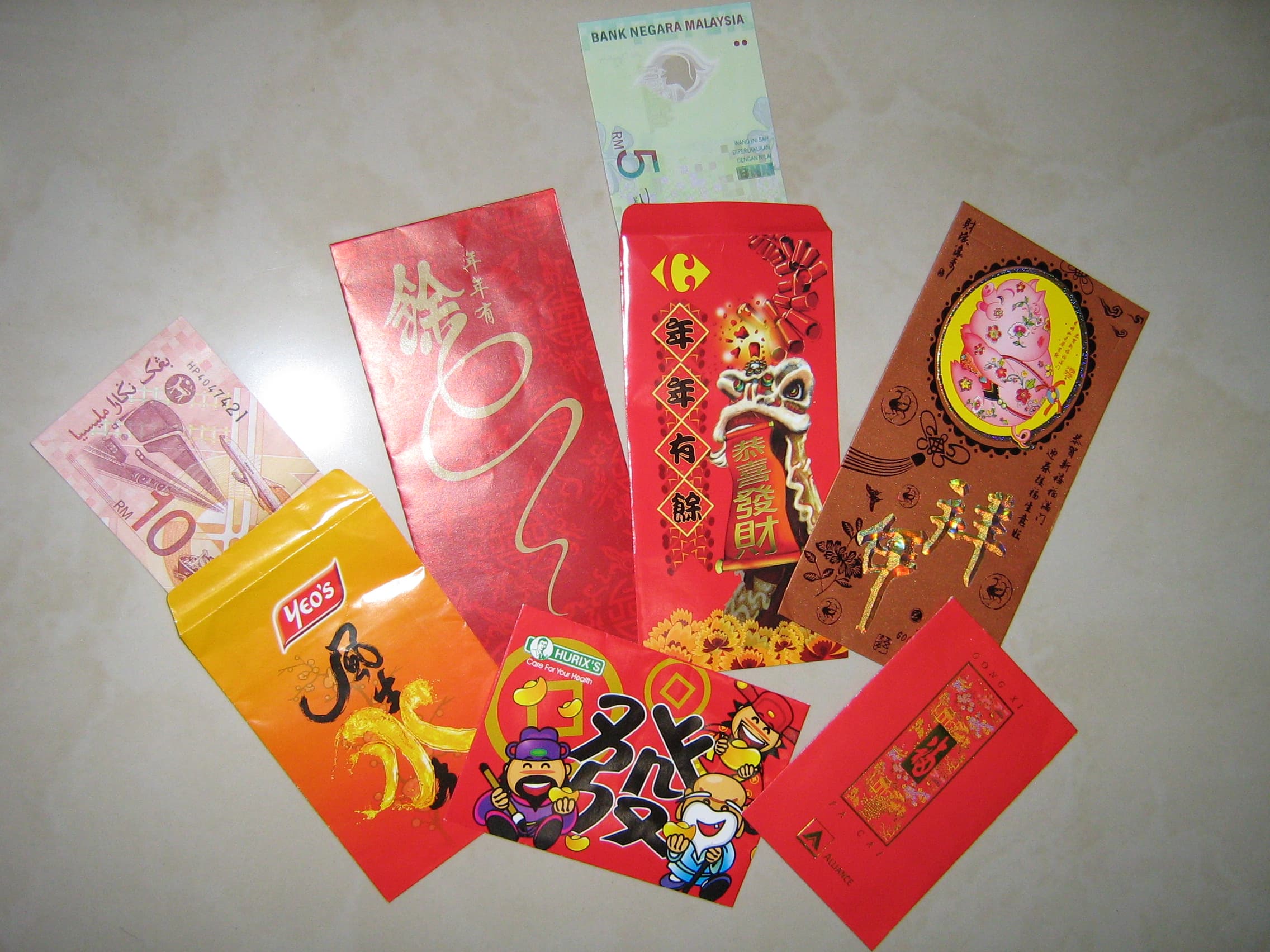 Enveloppes rouges traditionnelles chinoises ornées de motifs dorés, offertes lors des fêtes pour transmettre argent et bons voeux.