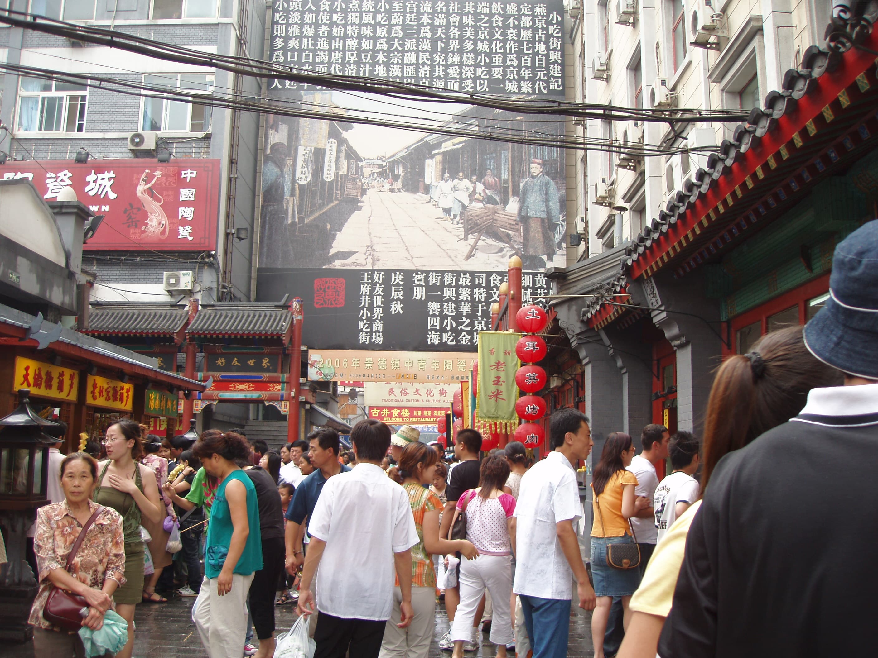 Foule de passants dans la rue commerçante de Wangfujing à Pékin, évoquant la mobilité urbaine encadrée par le système du hukou.