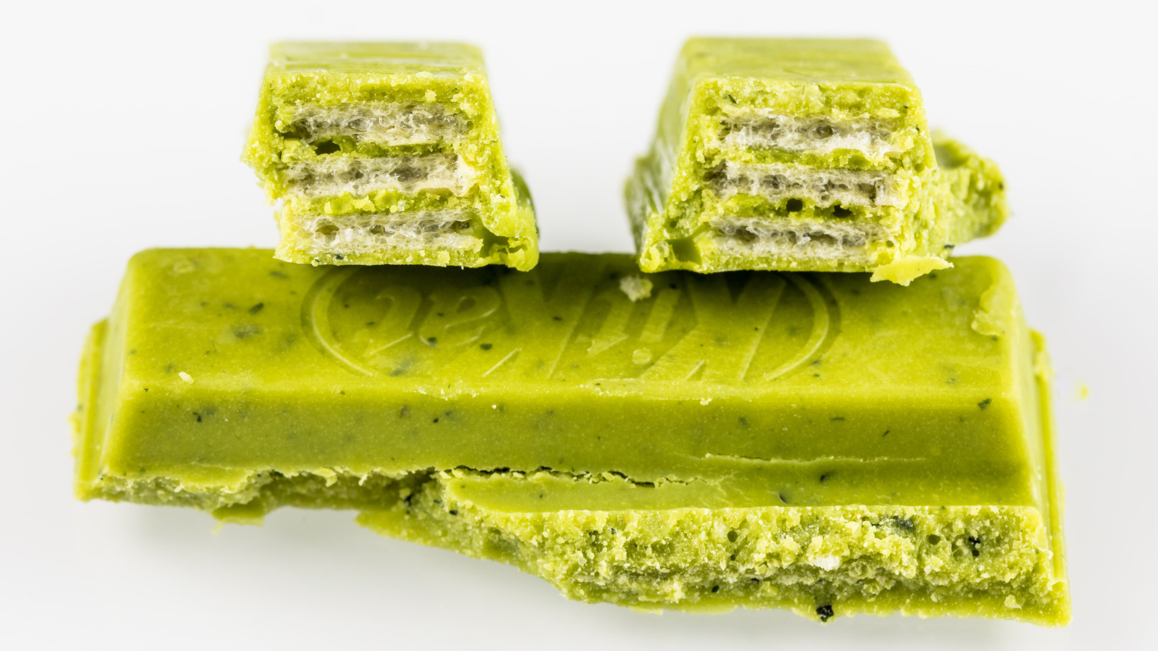 Barres de Kit Kat japonaises au matcha déballées et disposées en gros plan, illustrant les éditions limitées de saveurs propres au Japon.