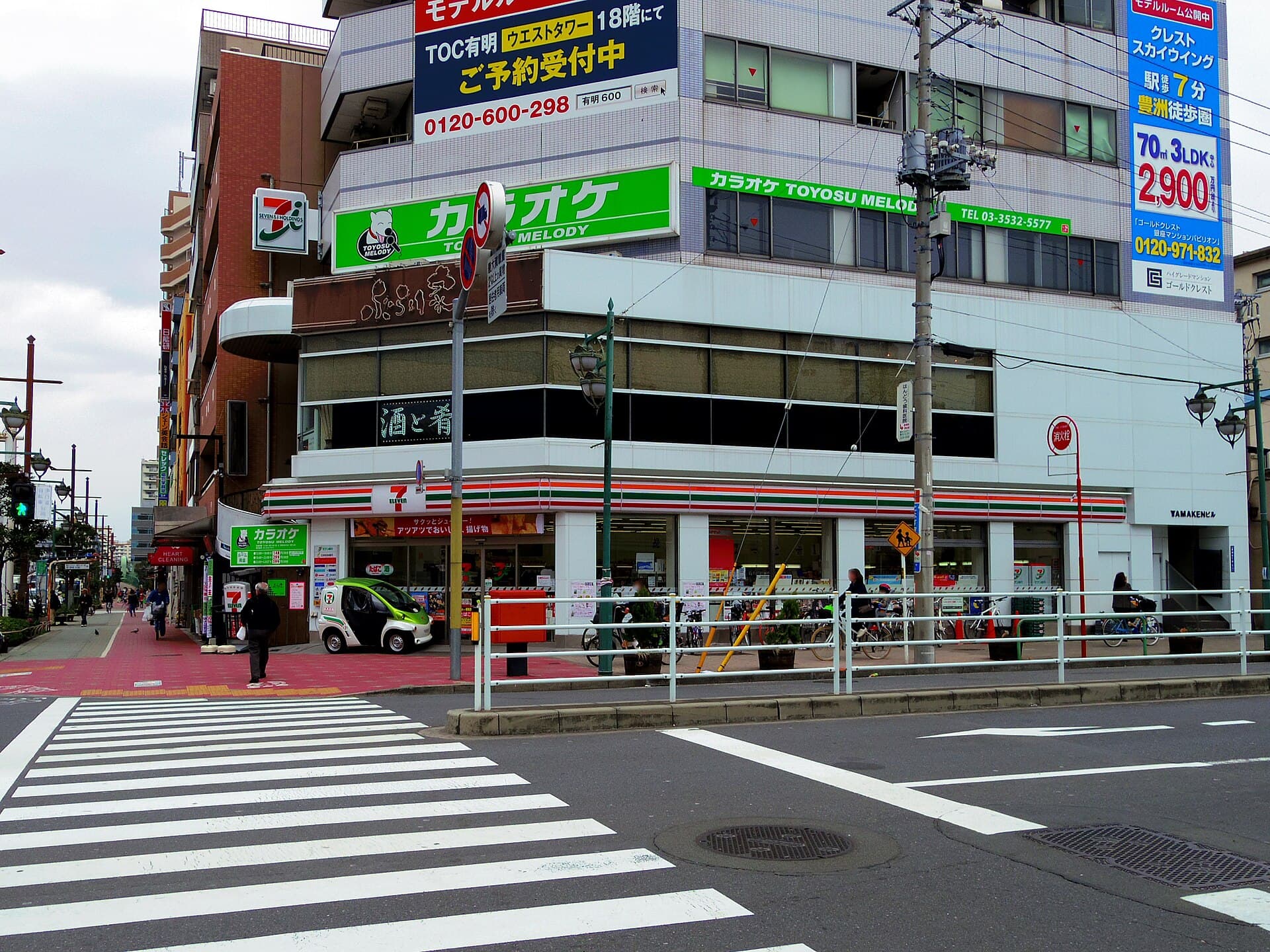 Devanture d'une supérette japonaise (konbini) 7-Eleven à Toyosu, Tokyo, avec son enseigne lumineuse caractéristique.