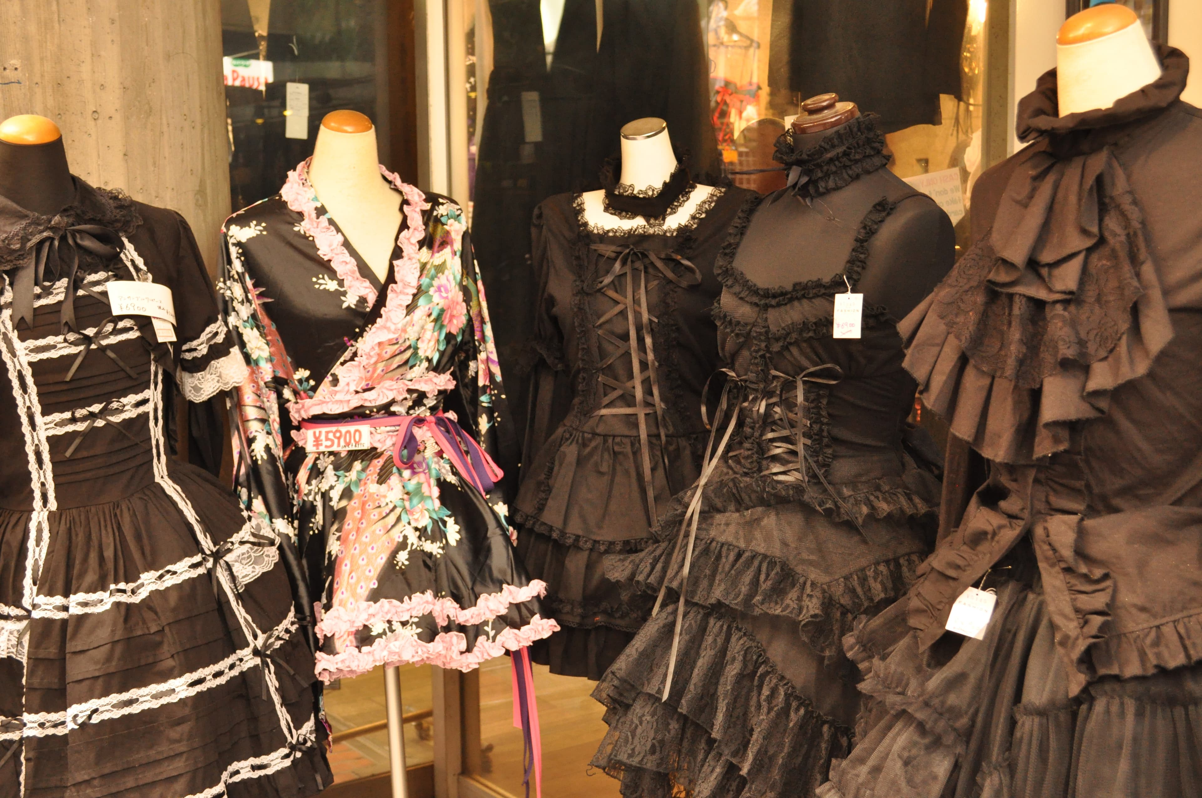 Jeune femme portant une tenue de mode gothic lolita japonaise, robe noire à volants et coiffe assortie