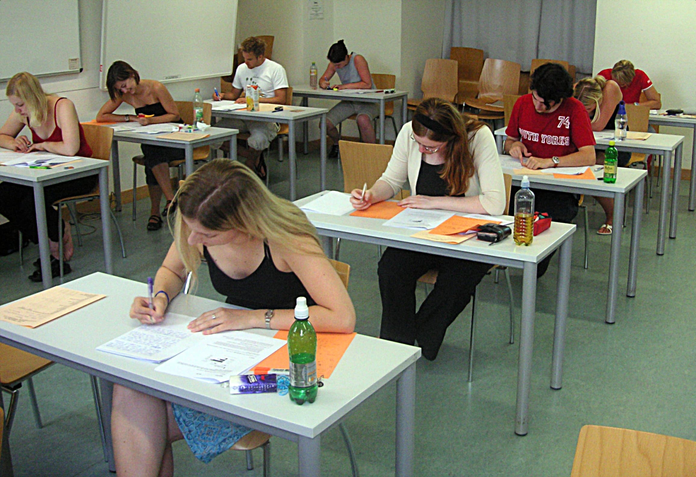 Élèves concentrés à leurs pupitres pendant une épreuve écrite, image de l'examen d'entrée à l'université.